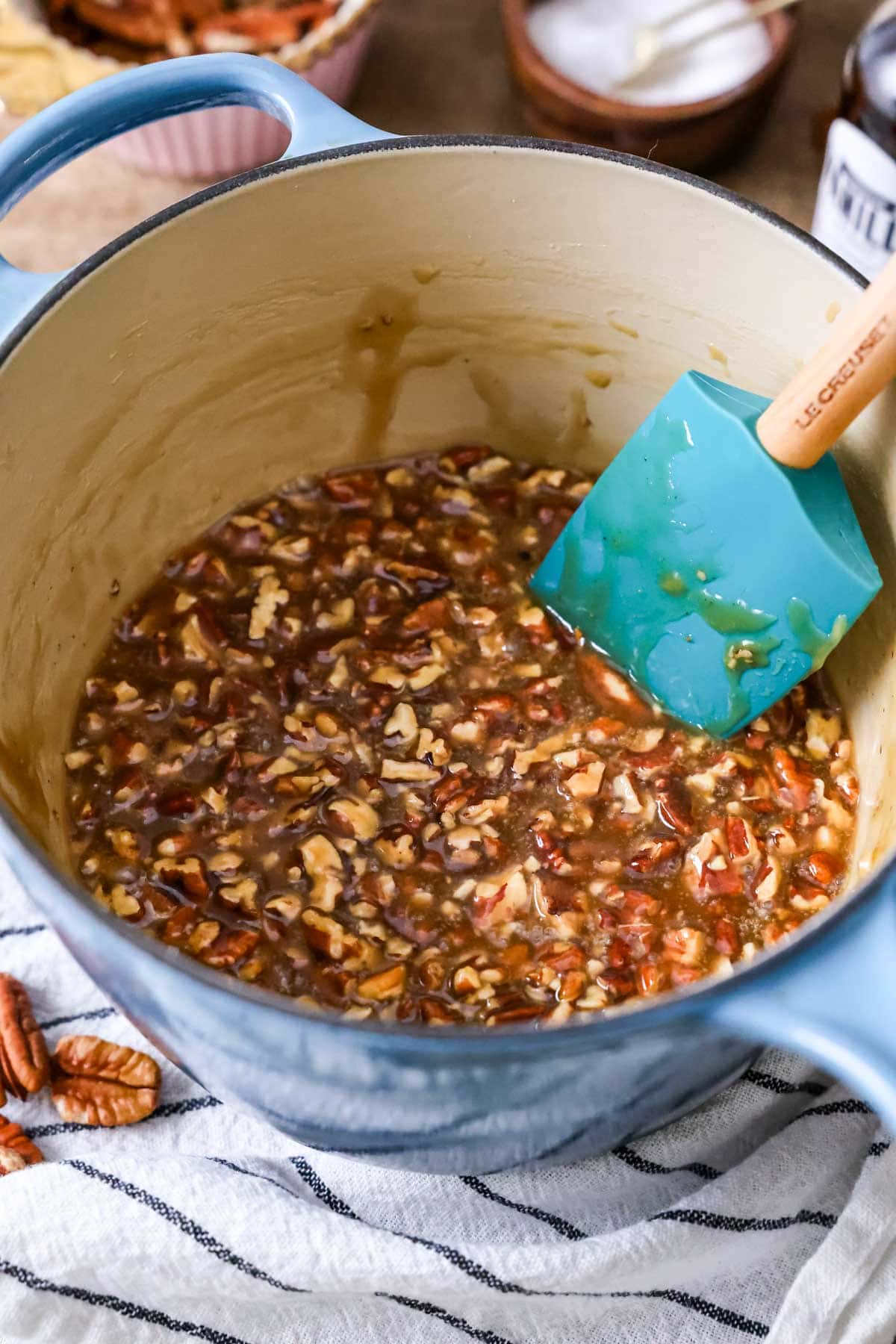Stirring a pecan filling on the stove with a spatula.