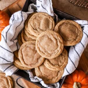 Overhead view of pumpkin spice cookies in a towel lined pan.
