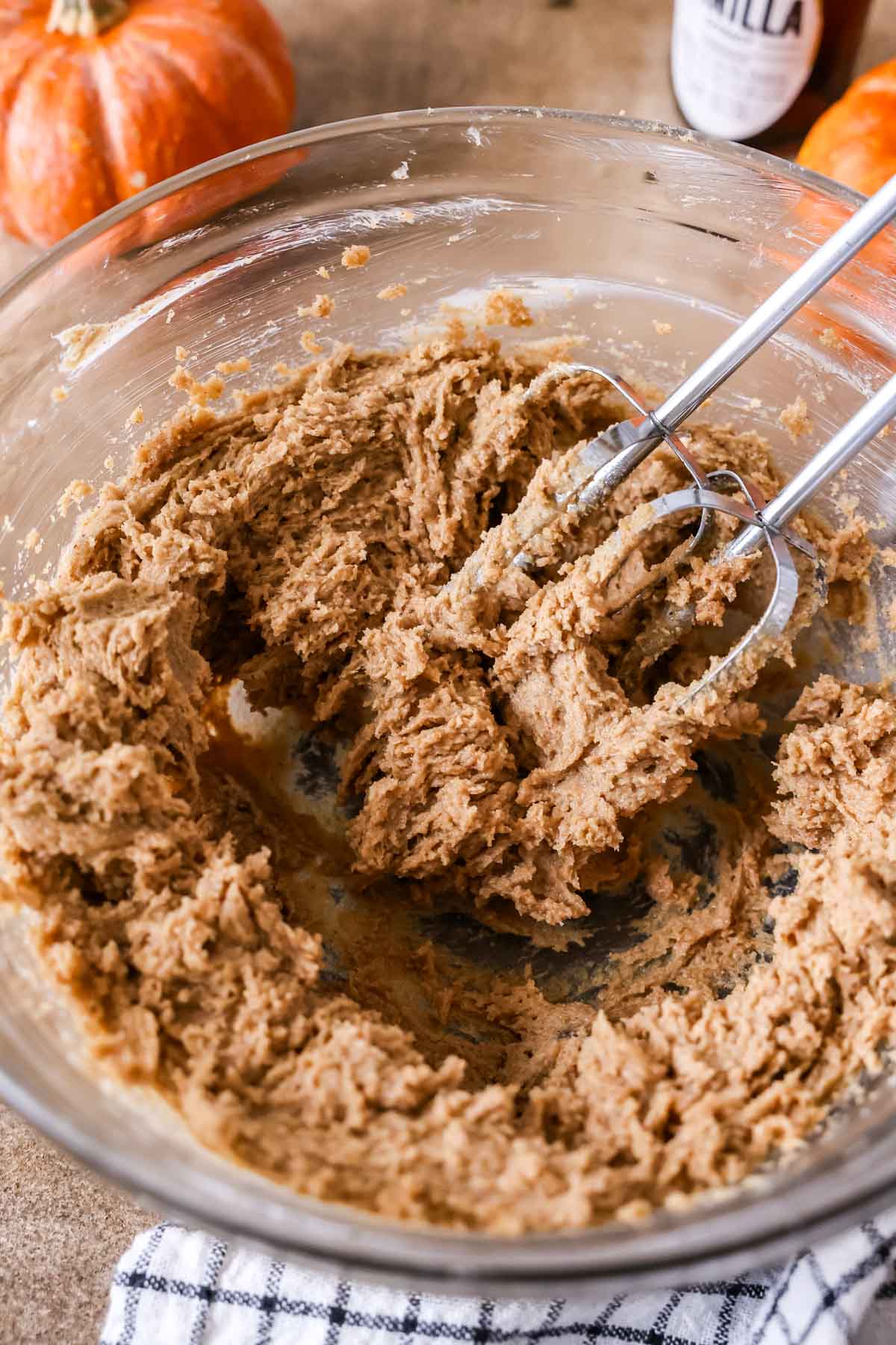 Close-up of cookie dough being mixed with an electric mixer.