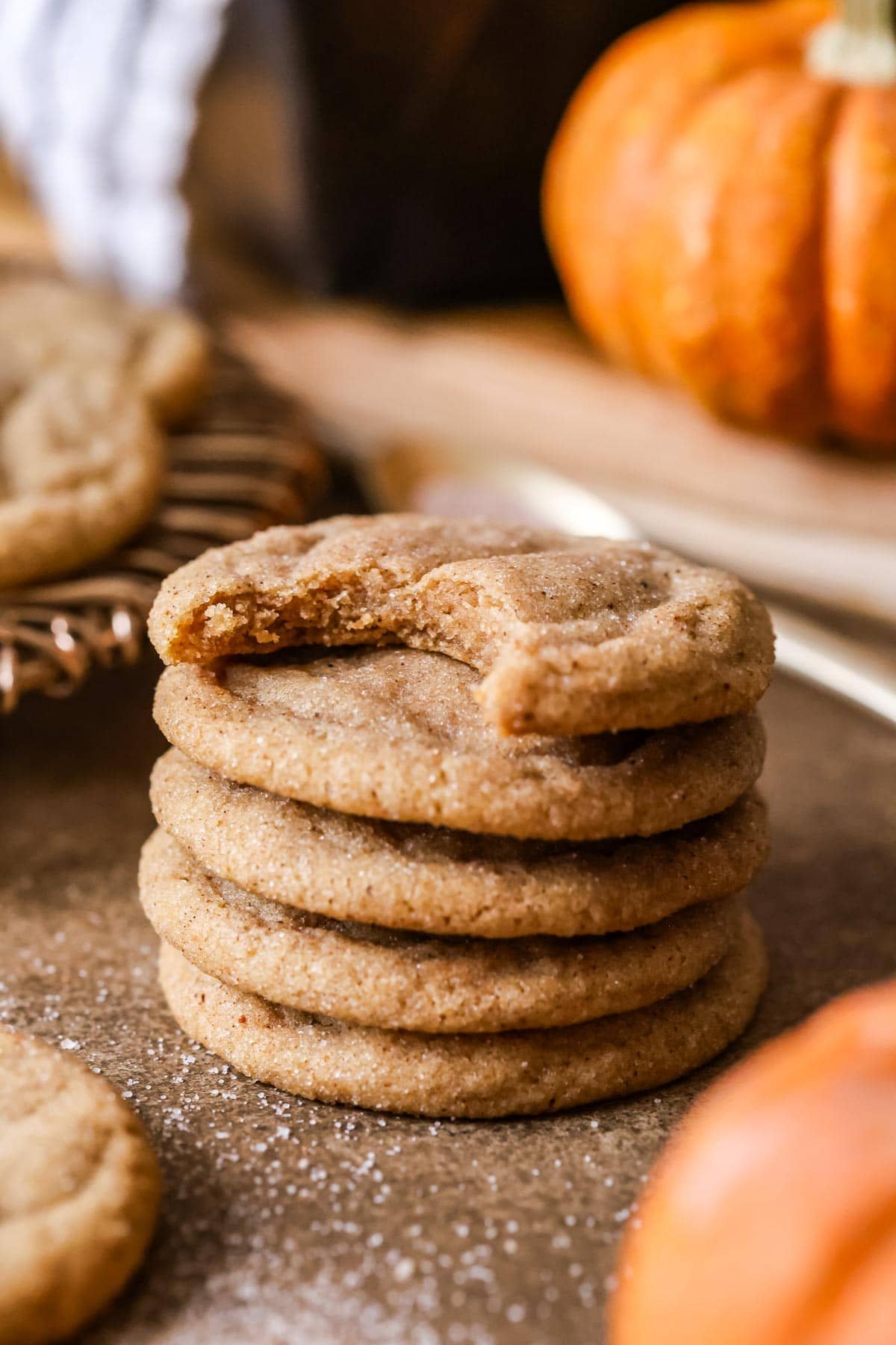 Stack of pumpkin spice cookies with the top cookie missing a bite.