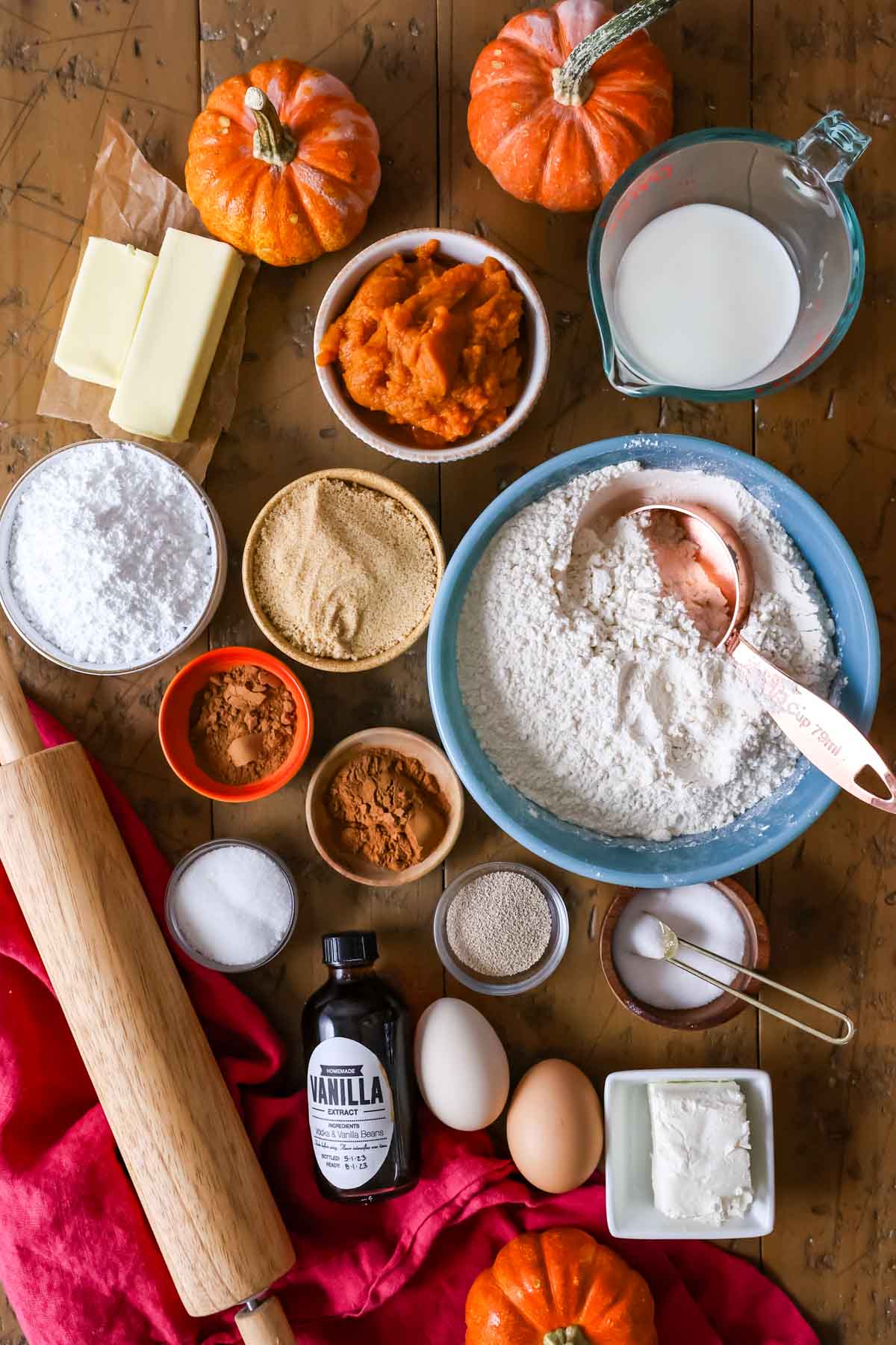 Overhead view of ingredients including pumpkin puree, yeast, bread flour, and more.