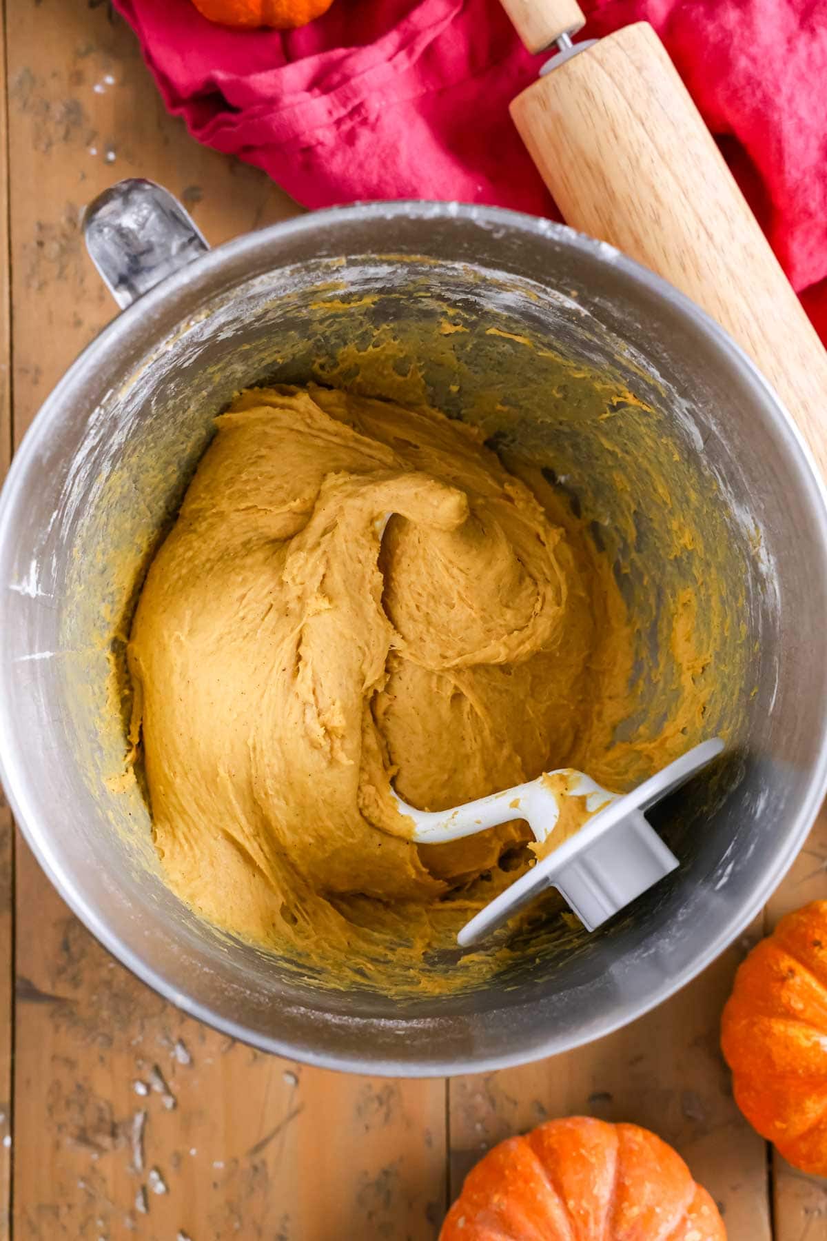 Overhead view of a bowl of pumpkin dough after kneading with a dough hook.