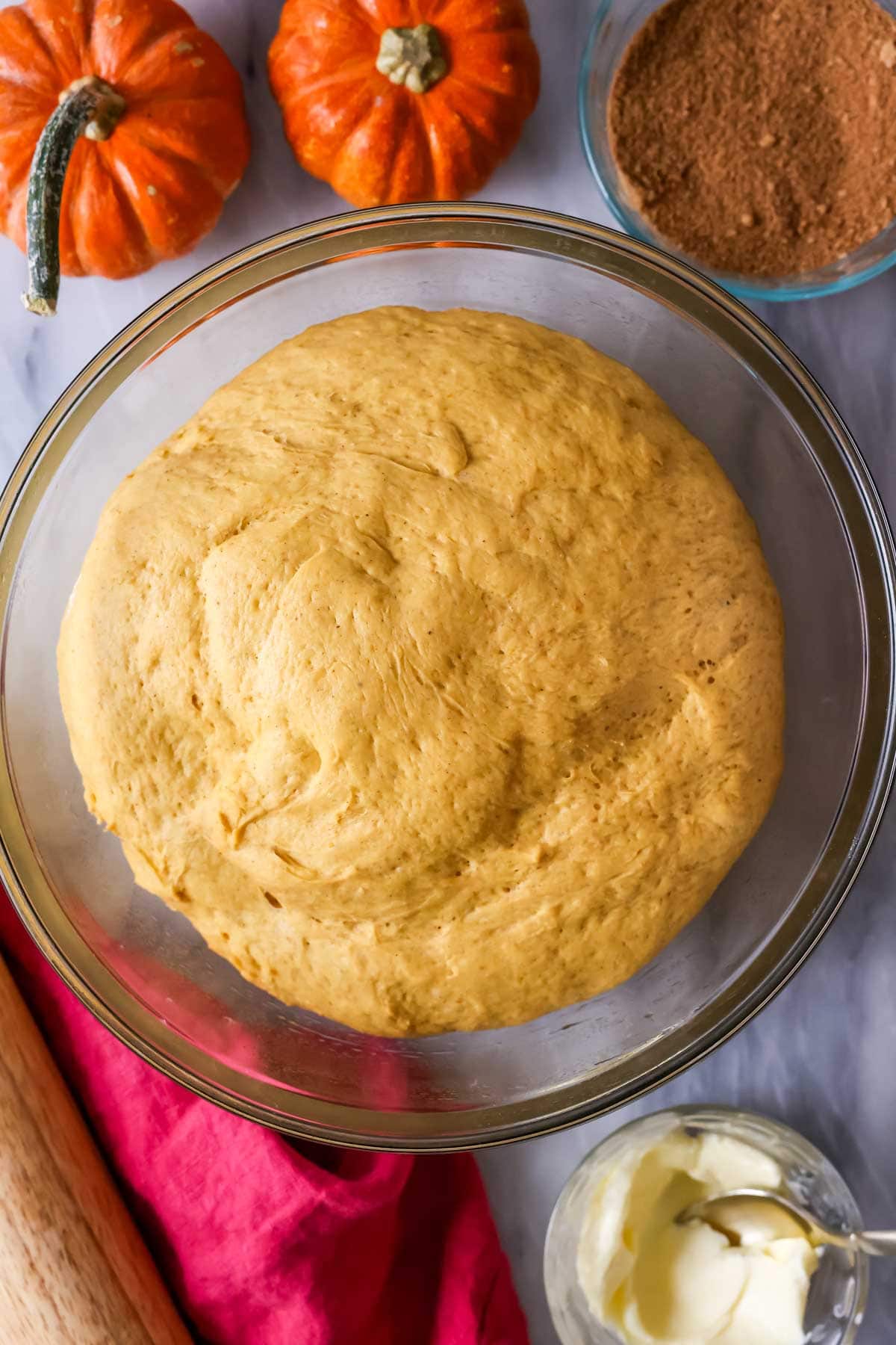 Overhead view of a bowl of pumpkin dough after rising.