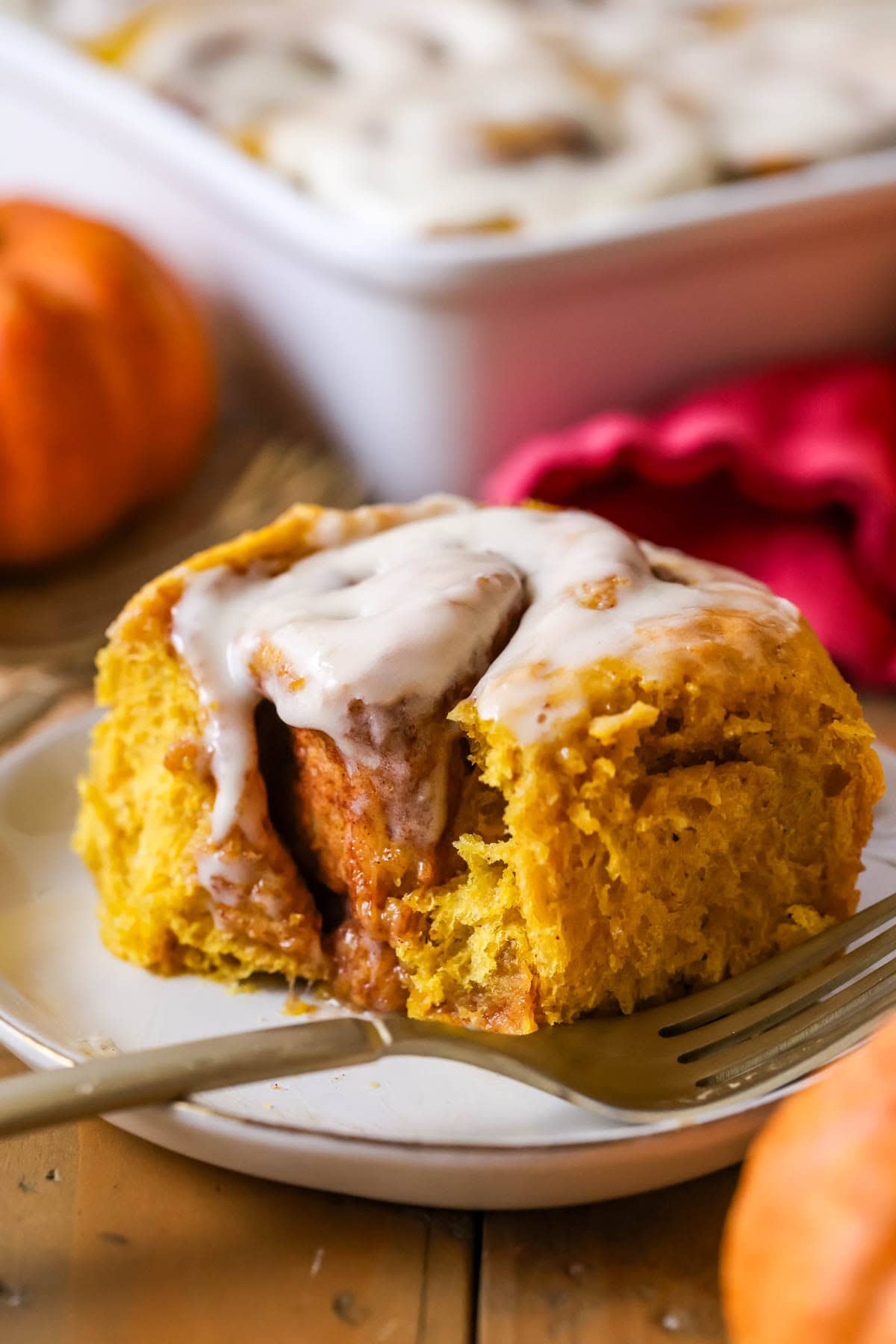 Bite missing from a cinnamon roll made with pumpkin puree.