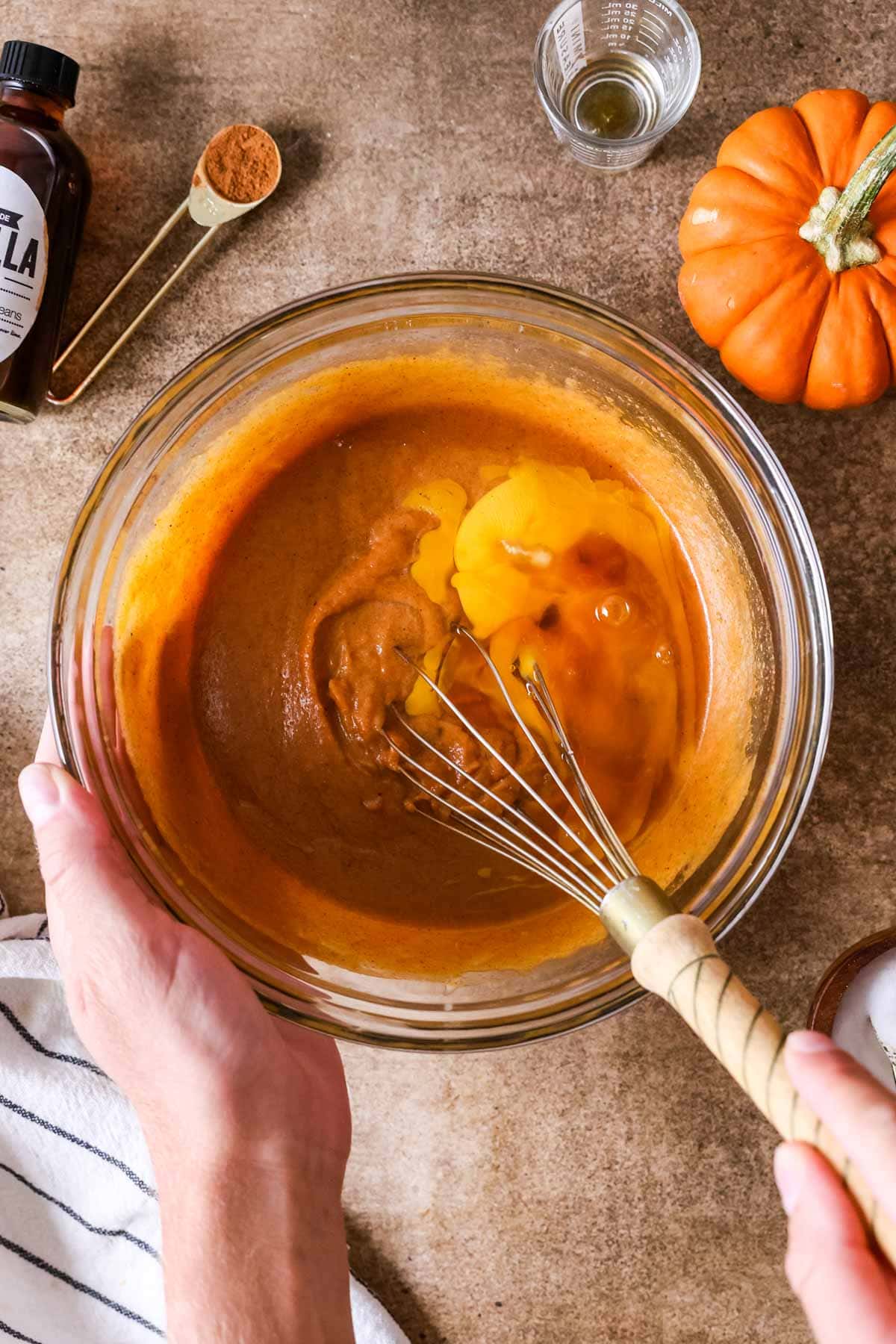 Overhead view of wet ingredients for muffin batter being whisked together.