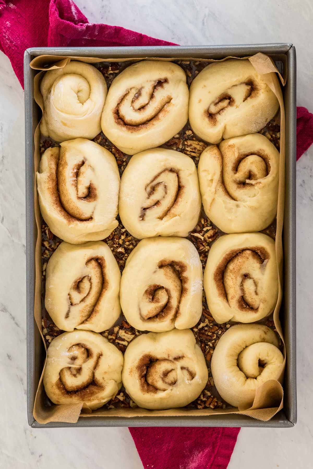 Overhead of puffed, risen sticky bun dough in pan before being baked.