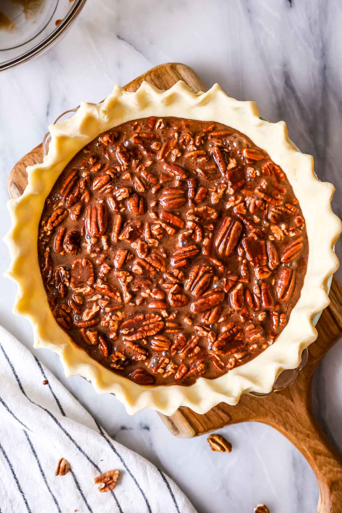 Overhead view of a chocolate pecan pie before baking.