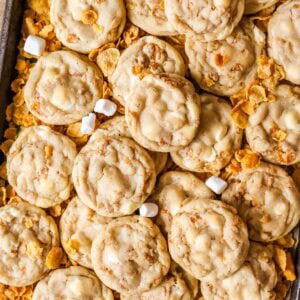 Overhead view of cornflake cookies surrounded by cornflakes and mini marshmallows.