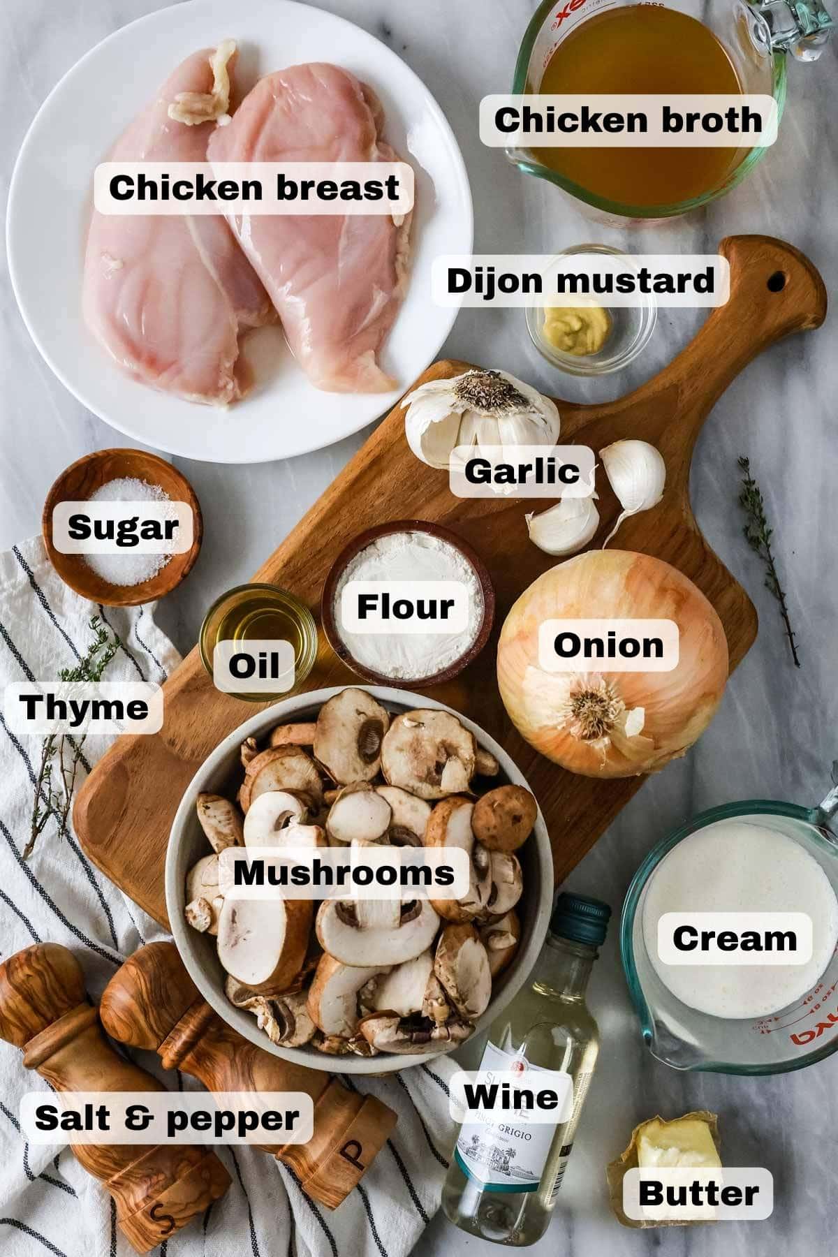 Overhead view of ingredients including mushrooms, chicken, onion, wine, and more.