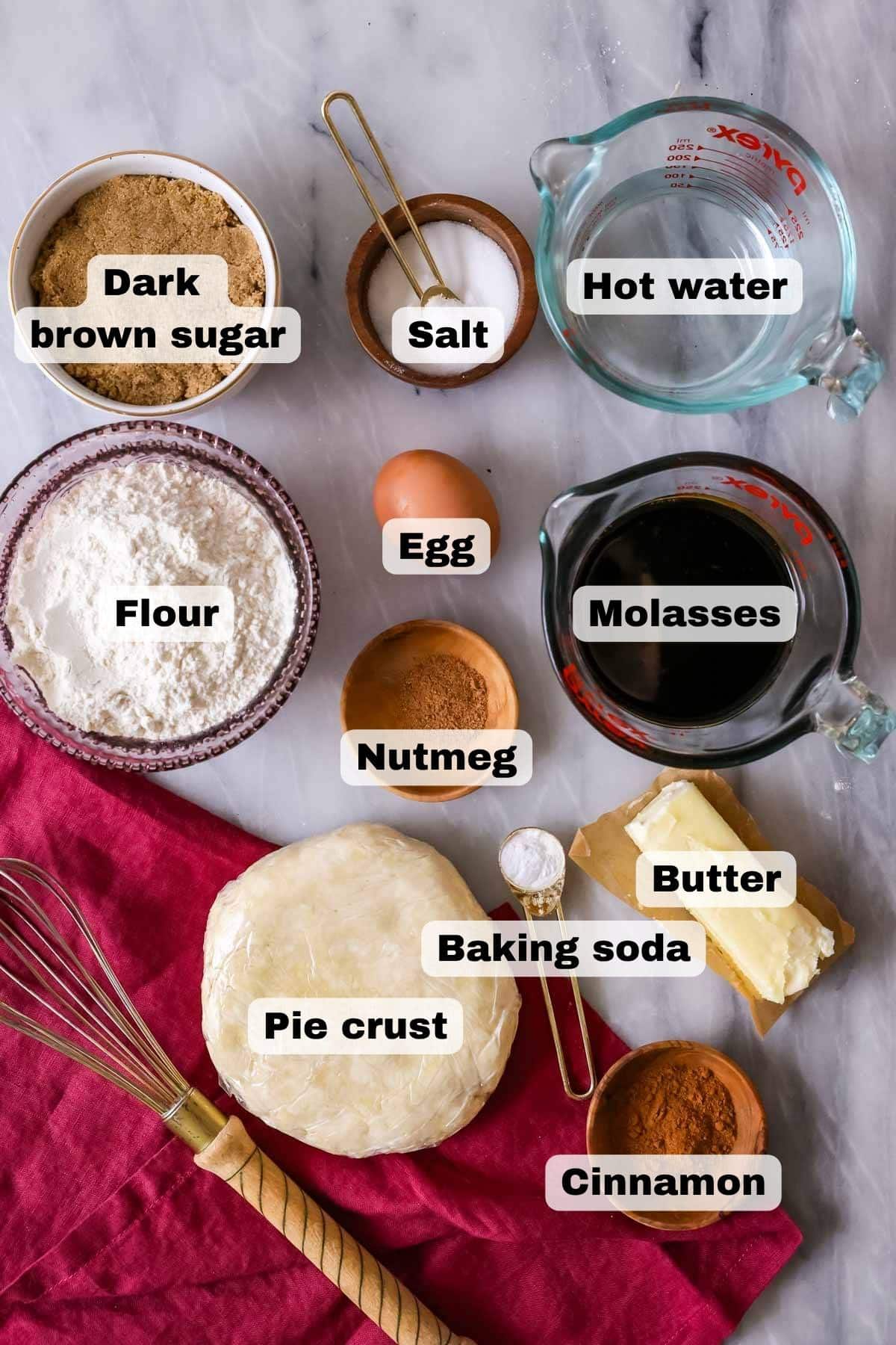 Overhead view of ingredients including pie crust, molasses, spices, egg, and more.